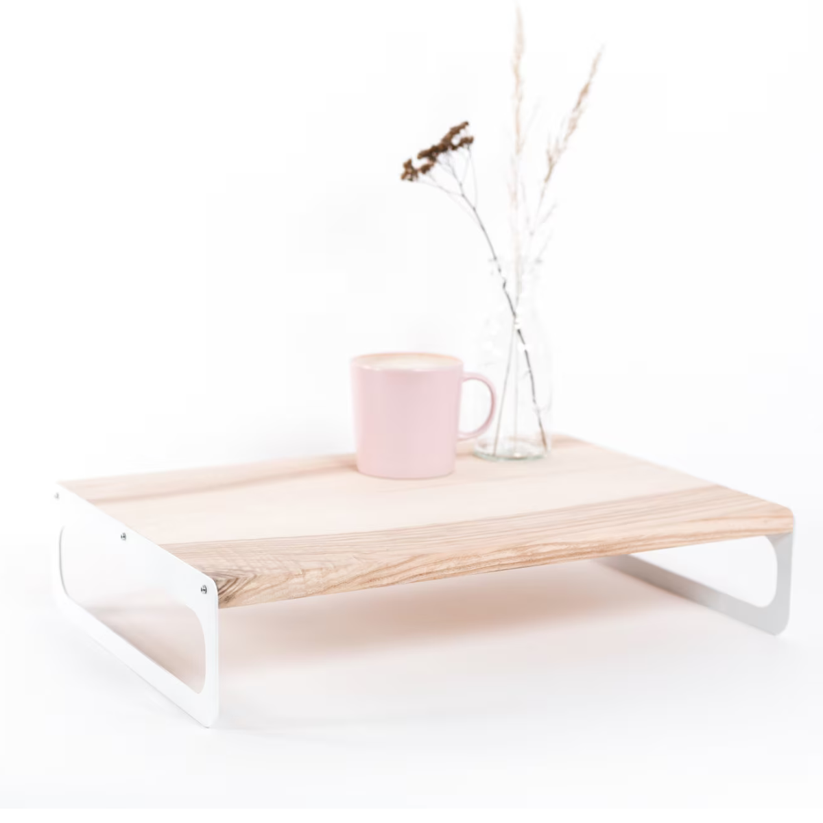 Wooden serving tray with a light ash finish, featuring sleek white metal handles. The tray is styled with a pink cup and a small vase with dried flowers, showcasing a clean, minimalist design.