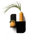 Modern dual-tier black metal shelf, featuring a tall, grooved orange vase on the top tier and a round, patterned orange vase with greenery on the lower tier. The shelf is secured with visible screws, adding a sleek and stylish element to the design.