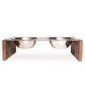 Front view of an elevated pet feeder with two stainless steel bowls set in a metal top, supported by wooden side panels.