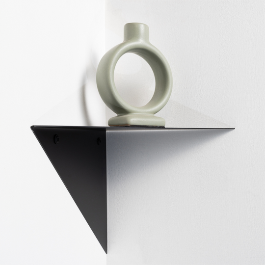 one small decorative corner shelf black with circular candlestick on top white background