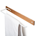 Wall-mounted wooden towel rack with a metal bar, white metal hooks, and visible screws, holding a white towel.