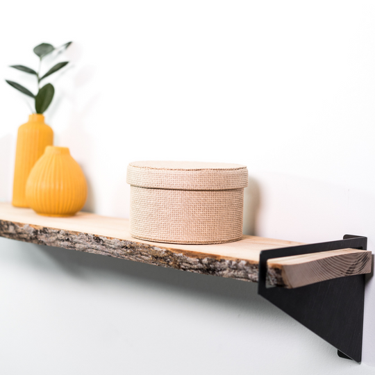 Close-up view of wooden shelf with geometric metal brackets and tree bark