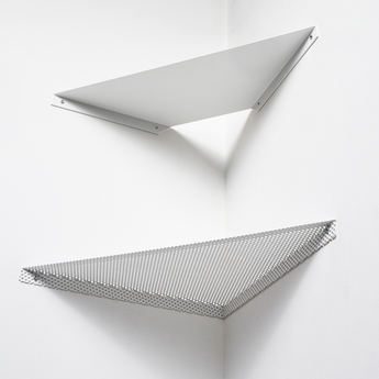 Two minimalist white wall-mounted shelves in a corner, one solid and the other perforated metal, arranged in a geometric style.