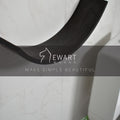 Close-up of a dark wood curved toilet paper holder mounted on a bathroom wall. The EWART WOODS logo and the slogan MAKE SIMPLE BEAUTIFUL are overlaid on the image.