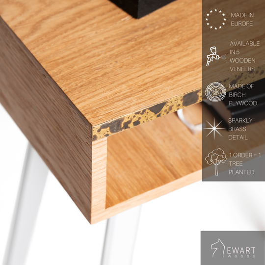 Close-up of rectangular wooden nightstand with brass design and white wooden legs and manufacturer specifics