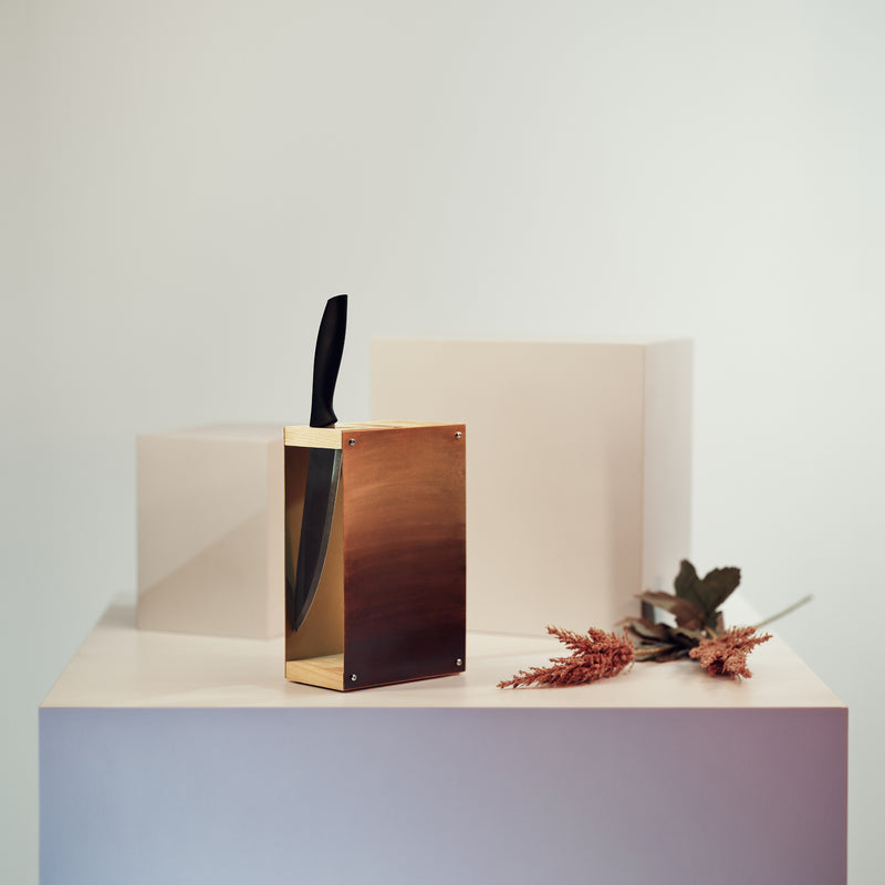 Knife block with gold painted metal and wooden slots for knives 