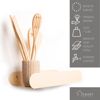 Beige, capsule-shaped metal rack with a powder-coated finish, wall-mounted, holding a ribbed container with wooden utensils. Text indicates it's made in Europe, holds 5 kg, and is made of high-quality steel.
