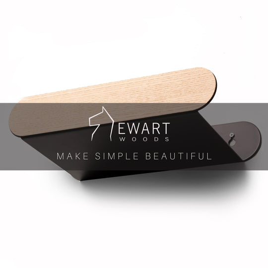 Capsule-style wall shelf with black and wood finish, mounted with screws. Ewart Woods logo and slogan across the center.