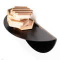 Black wall-mounted half-circle shelf holding stacked hexagonal wooden office organizers.
