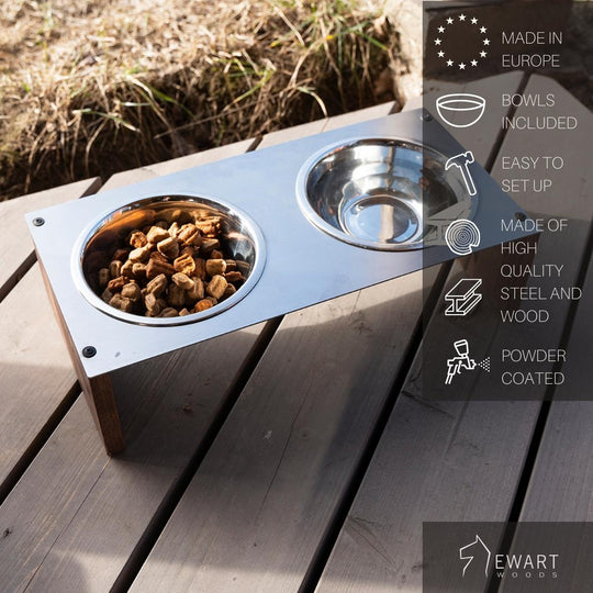 Raised dog feeder with a powder-coated metal top and wooden legs, including two stainless steel bowls—one filled with kibble. Made in Europe with high-quality materials.