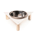Modern elevated dog bowl stand with a triangular metal top, supported by three cylindrical wooden legs secured with visible screws, featuring a stainless steel bowl in the center.