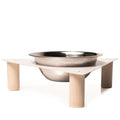 Elevated dog bowl with a triangular metal top and wooden cylindrical legs, featuring a single stainless steel bowl.