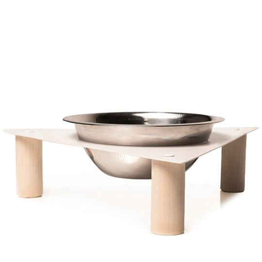 Elevated dog bowl with a triangular metal top and wooden cylindrical legs, featuring a single stainless steel bowl.