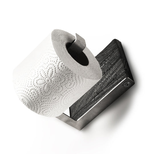Close-up of a burned ash wood and stainless steel toilet paper holder with a single roll of toilet paper. The design features a sleek metal bar and textured wood