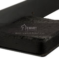Close-up of a wall-mounted toilet paper holder with a matte black steel plate and a burned wood shelf, showcasing the unique texture of the wood with the brand logo overlayed.