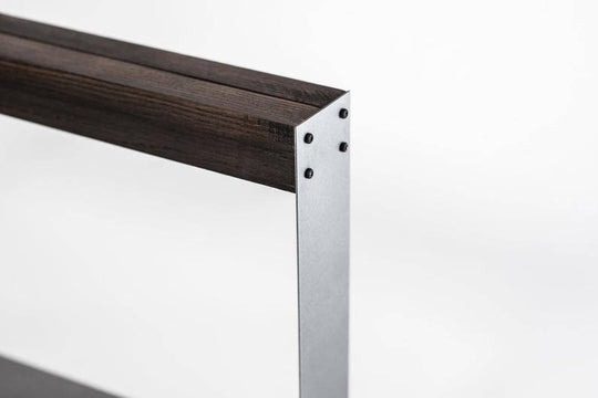 Close-up of a minimalist knife holder featuring a dark wooden top, sleek silver metal frame, and visible black screws securing the structure.