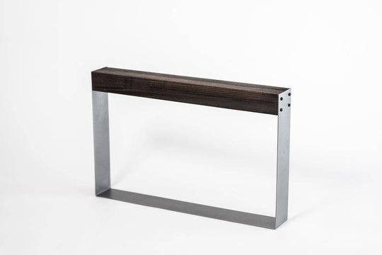 Minimalist knife holder with a dark wooden top and rectangular silver metal frame, featuring exposed black screws on one side, standing empty against a white background.