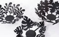 Set of three black metal decorative bowls in modern industrial style, featuring botanical cutout designs of leaves and plants.