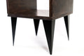 Close-up of a dark-stained wooden side table featuring sleek black tapered legs, highlighting its sturdy and minimalist design.